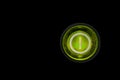 Round green power on and off button or switch with retro illumination glowing in the dark macro Royalty Free Stock Photo