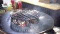 Round grill with flat roasting. Round grille in the center with a fire.