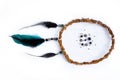 handmade Dreamcatcher made of willow branches and green, black feathers, placed horizontally on a pure white background