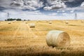 Round hay bales on prairie landscape with distant transmission towers in Rocky View County Alberta Canada Royalty Free Stock Photo