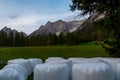 Moos - Round hay bales in plastic wrap cover on alpine meadow in panoramic valley Fischleintal Royalty Free Stock Photo
