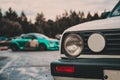 Round headlights of an old vintage car of white color close-up. In the background is a green car Royalty Free Stock Photo