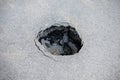 Round hole in gray asphalt, damaged road