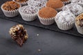 Round homemade chocolates in different kind of decor on paper substrates. Shallow depth of field. Selective focus