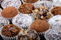 Round homemade chocolates in different kind of decor on paper substrates. Shallow depth of field. Selective focus