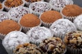 Round homemade chocolates in different kind of decor on paper substrates. Shallow depth of field. Selective focus