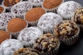 Round homemade chocolates in different kind of decor on paper substrates. Shallow depth of field. Selective focus