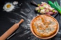 Round homemade meat pie on a black wooden background in a beautiful composition. top view. Space. Close-up Royalty Free Stock Photo