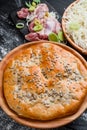 Round homemade meat pie on a black wooden background in a beautiful composition. top view. Space. Close-up Royalty Free Stock Photo