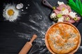 Round homemade meat pie on a black wooden background in a beautiful composition. top view. Space. Close-up Royalty Free Stock Photo