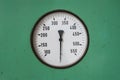 Round Industrial Thermometer On A Machine Green Background