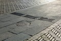 Round iron manhole with hatches rectangular gratings of the drainage system on the road.