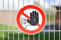 Red round `Keep out` warning sign with person holding up hand in red circle at fence protecting construction site Royalty Free Stock Photo