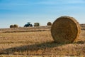 large bales and tractor with trailed bale machine collect straw in the field , hay collection in the summer Royalty Free Stock Photo