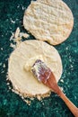 Round layered napoleon cake with custard and sprinkled crumbs on a green marble table, top view. The process of cooking, recipe