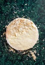 Round layered napoleon cake with custard and sprinkled crumbs on a green marble table, top view. The process of cooking, recipe