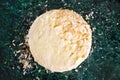 Round layered napoleon cake with custard and sprinkled crumbs on a green marble table, top view. The process of cooking, recipe