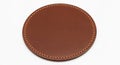 Round leather coaster made of smooth brown leather with visible stitching along Royalty Free Stock Photo