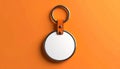 Round leather keychain with blank white insert and metal ring on orange surface key ring Royalty Free Stock Photo