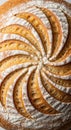 A round loaf of artisan bread with an intricate pattern of slashes on its surface, dusted Royalty Free Stock Photo