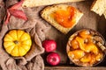 Round loaf of artisan wheat bread with pumpkin and apple in a wooden tray.