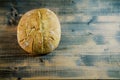 Round loaf of bread lies on the left on a wooden table. Top view Royalty Free Stock Photo