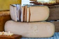 Round mature French Tomme goat cheese with cutted pieces on farmers market in France