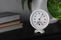 Round mechanical hygrometer on black shelf. Space for text Royalty Free Stock Photo