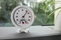Round mechanical hygrometer on book near window. Space for text Royalty Free Stock Photo