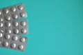 Round medical tablets in three packs, tablets packed in blisters on the left side with copyspace on blue background Royalty Free Stock Photo