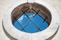 Round medieval window with bars blue sky view - Abstract Concept Background - Indoors Outdoors Concept - Round window with window