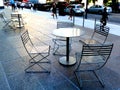 Round metal tables and patio chairs on public street terrace in Toronto