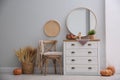 Round mirror and chest of drawers near grey wall in hallway. Interior design Royalty Free Stock Photo