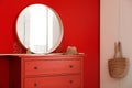 Round mirror and chest of drawers near wall in room. Modern interior design Royalty Free Stock Photo