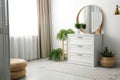 Round mirror and chest of drawers near wall in room. Modern interior design Royalty Free Stock Photo