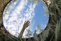 Round Mirror In The Grass - Trendy Image, Close To Nature. Hand in the mirror against the blue sky