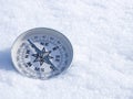 Round modern compass on the white snow, space for text. Concept for travelling and active lifestyle