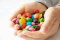 Round, multi-colored, chocolates. A pile of multi-colored candies. A child holds a candy Royalty Free Stock Photo