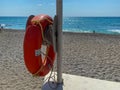 Round non-sinking red life buoy for safety to save the lives of drowning people tourists on the beach in a warm eastern tropical