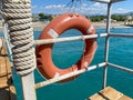 Round non-sinking red lifebuoy for safety to save the lives of drowning people tourists against the background of the sea in a Royalty Free Stock Photo
