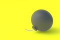 Round old bomb with fuze on yellow background. Copy space
