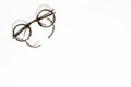 Round old eyeglasses for vision correction lie on a white background Royalty Free Stock Photo