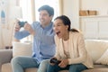 Excited emotional young family married couple playing console video games