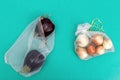 Round onions and fresh ripe eggplants in eco natural bags sewing from mesh cloth