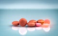 Round orange and pink tablet pills on gray background. Pharmaceutical industry. Drug use in hospital and daily life. Painkiller