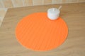 Round orange tablemat and sugar bowl on table