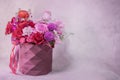 Round paper geometric pattern box vase with lush bouquet of red, light pink, purple, white cute delicate small roses Royalty Free Stock Photo