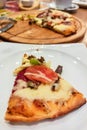 Round pide or Turkish pizza with cheese, sujuk and different types of meat on a wooden tray. selective focus. small focus area Royalty Free Stock Photo