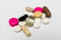 Round pills and oval hard and soft capsules on white background Royalty Free Stock Photo