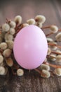 Round pink Easter egg and willow branches on a wooden background Royalty Free Stock Photo